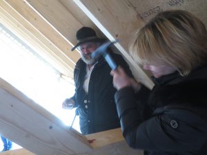 Einschlagen letzter Nagel durch die Bauherrin